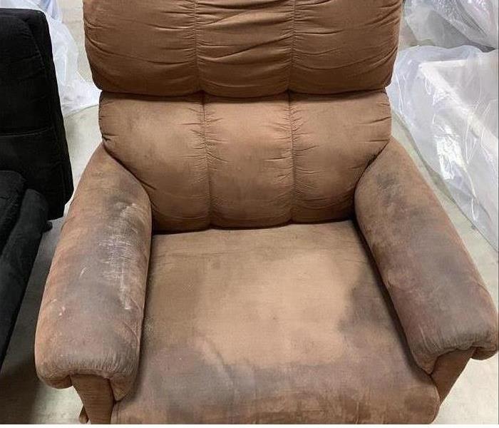 Brown recliner covered in soot/smoke damage